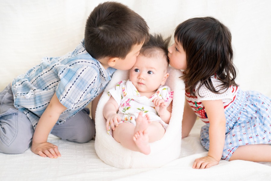 siblings kissing a 3 months old baby 2022 03 19 00 58 39 utc
