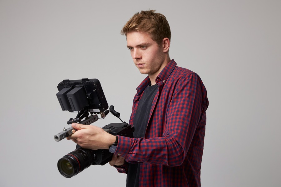 studio portrait of male videographer with film cam 2021 08 26 16 12 59 utc